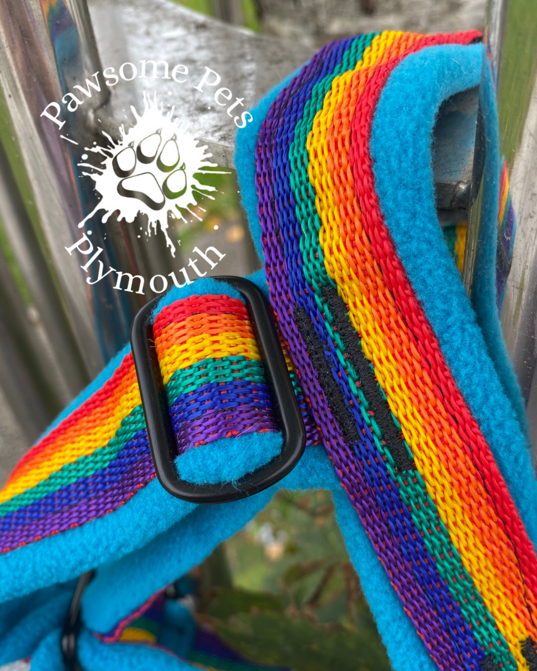 close up of stitching on a Rainbow and blue pet harness with 'Pawsome Pets Plymouth' logo in the background